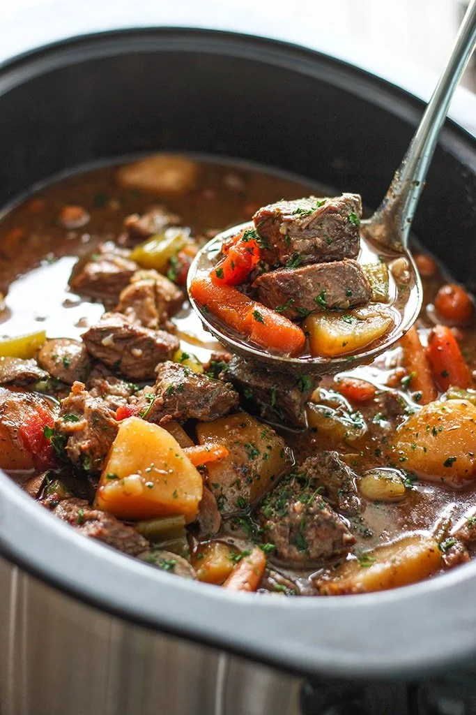 Bowl of slow cooker beef stew with vegetables and herbs